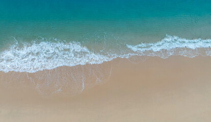 Tropical Beach with the soft wave water of the sea on the sandy beach background as texture with splashes and bubbles