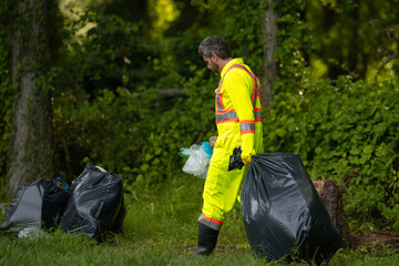 Volunteer man collecting garbage, picking up waste at nature. Land pollution, environmental problem. Landfill a pile of plastic garbage. Pollution of nature. Ecology concept. Pollution environmental.