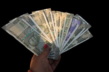 Hand holding Indian 500 rupee note isolated on black background representing Indian currency concepts like tax, loan, investment, banking, and financial planning. Copy space 