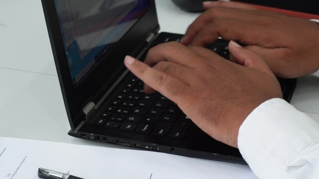 A freelance developer's hands typing program code on a laptop keyboard in a workspace. A businessman working in an office. A scriptwriter writing text on a computer keyboard.