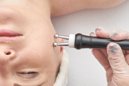 Caucasian female receiving anti aging facial treatment with microcurrent therapy in spa.