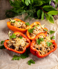 Stuffed peppers with herbs and cheese on the rustic background. Selective focus. Shallow depth of field.