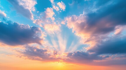 Obraz premium A vibrant sunset sky filled with colorful clouds and rays of sunlight breaking through, creating a serene and picturesque atmosphere.