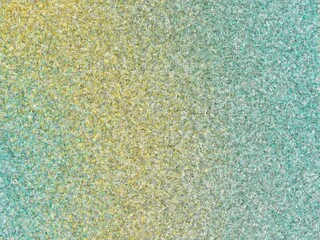 Abstract background with a gradient transition from yellow-gold to teal, featuring a textured, granular surface.