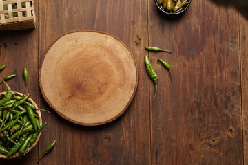 Sweet and sour green chili pickles with brown wood background