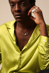 Cropped portrait of young African American man looking at the camera and posing over light background. Vertical mock-up.
