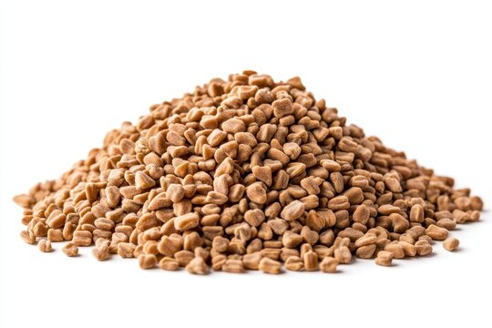 Heap of dried raw fenugreek seeds for making helba tea cooking or local Egyptian medicine set against a white background