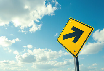 Yellow arrow road sign against a blue sky with white clouds