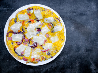 Scrambled eggs, omelette with ham, onion and cheese baked top view