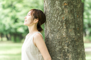 森の中で森林浴する女性(ヨガ・エコ・SDGs・環境・デトックス・オーガニック・ナチュラル)
