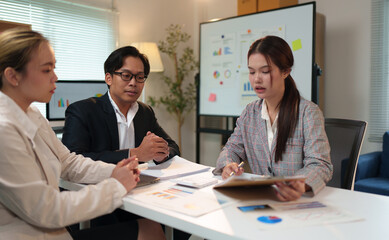 Group of business people, investors talking and meeting using documents and laptops to analyze and discuss. Presentation of financial report situation in the office. Teamwork concept, startup business