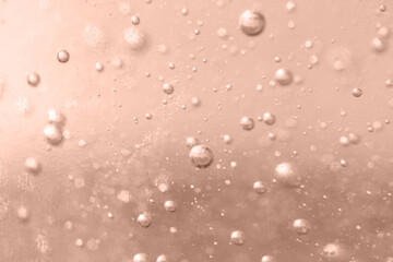 The surface of the cosmetic product has bubbles. blurred background in mocha mousse color. soft focus