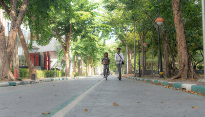 Fototapeta premium Commuting to work with bicycle. Young business person cycling and riding electric scooter to office in downtown district. Modern diversity people use eco transportation in city. Sustainable lifestyle.