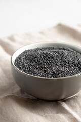 Raw Organic Dry Poppyseeds in a Bowl, side view.