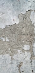The cement walls of a house are worn and peeling