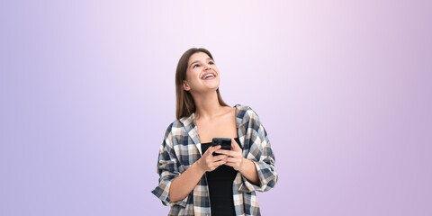 Happy woman using smartphone on light purple background.