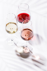 Three wine glasses filled with red, white, and rose wine