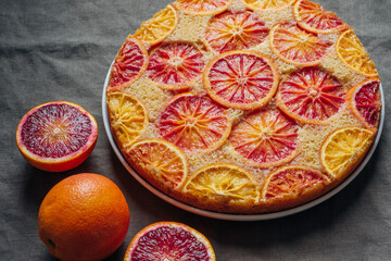 Delisious freshly baked homemade blood orange upside-down cake on grey background. Popular winter holiday dessert.