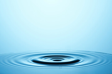Water Drop Ripple: A single drop of water creates concentric ripples in a tranquil blue pool,...