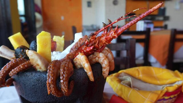 Close up molcajete seafood bowl with lobster, shrimps, fish, mussels, pineapple