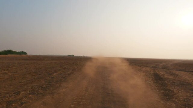 4K view of desert sand flying after off-road vehicle passing through desert in kutch, Gujarat, india. Desert safari adventure sports. Travel and holidays background.