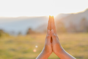 Closeup Young woman hands place together like praying worship at sunset.worship god with christian...