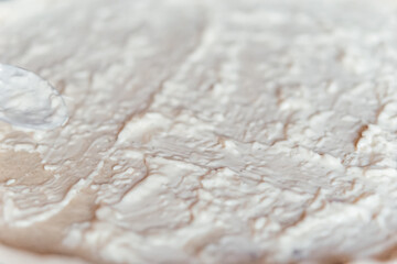 making pizza cooking at home spreading souse cream cheese on a dough