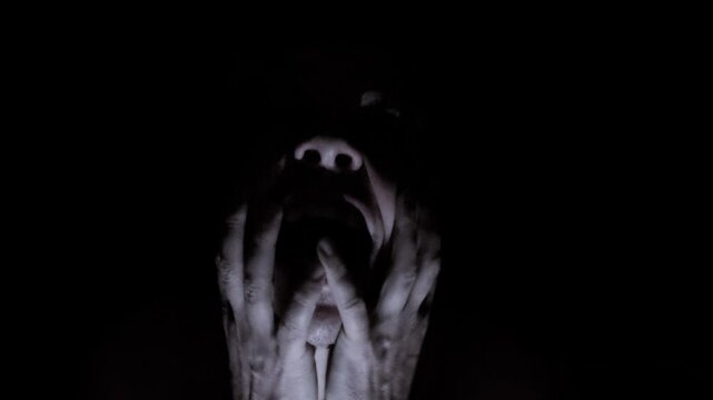 Disturbing portrait of a man experiencing a mental breakdown, screaming and holding his head in pain