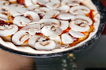 Making pizza with mushrooms and tomato souse