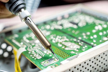 Man technician soldering a electric circuit board