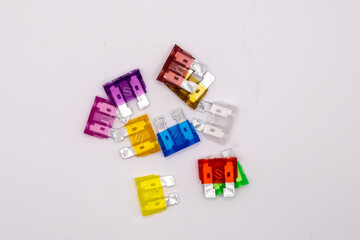 The images showcases a vibrant array of automotive fuses in various colors and amperages, arranged...