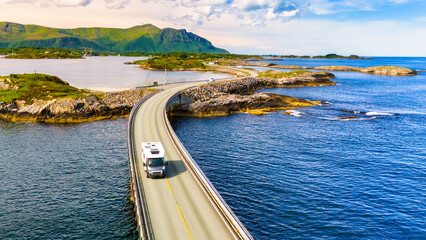 An RV or motorhome drives along the Atlantic Road Bridge in Norway, a scenic bridge that connects several islands.