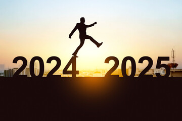 Silhouette of businessman crossing 2025 from 2024 with sunrise background