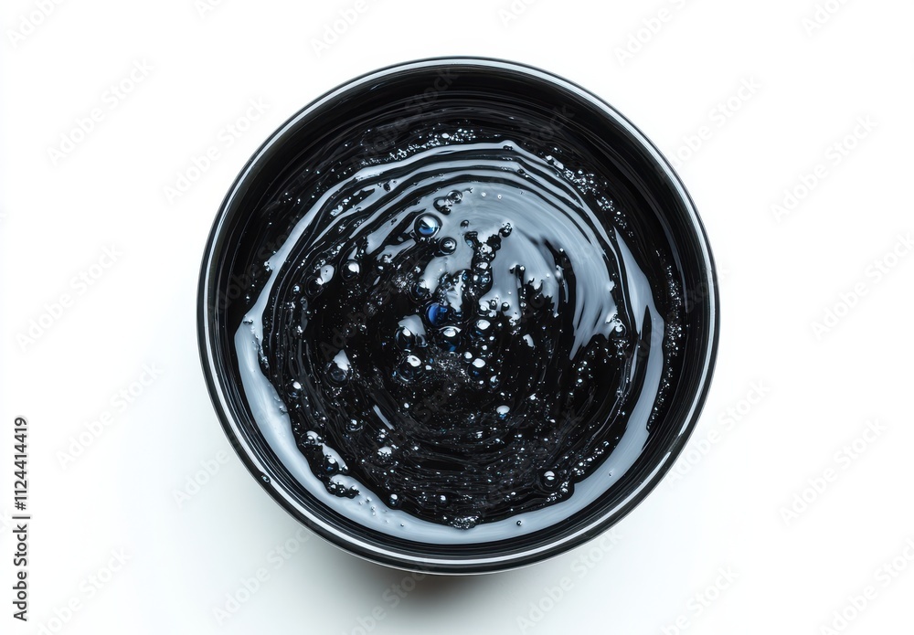Poster glossy black liquid creating abstract swirls and bubbles in a shallow bowl on white background for a
