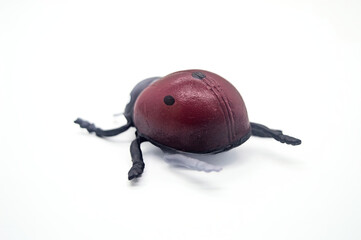 Realistic toy ladybug isolated on white background. Detailed red and black design with six legs and...