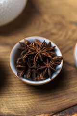 Beautifully arranged star anise spices in a decorative bowl placed on a rustic wooden surface