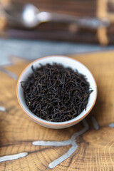 Enjoying Premium Black Tea Leaves Presented in an Exquisite Wooden Bowl for the Best Experience