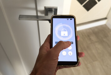smart house, home automation, device with app icons. Man uses his smartphone with smarthome security app to unlock the door of his house.