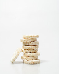 wheat rice breads tower, biscuits on a white background crumbled and whole