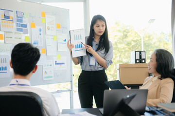 The boss stands near the board with graphs, demonstrates statistics, various personnel attending the training,