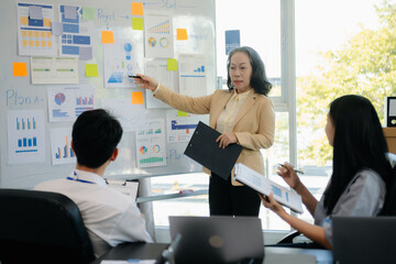 The boss stands near the board with graphs, demonstrates statistics, various personnel attending the training,