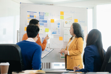 Group of young Asian business people discussing business plan at modern startup