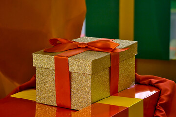 golden gift box tied with a red ribbon