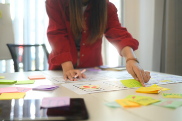 Close up of designers discussing app layout and interface wireframes during a brainstorming session
