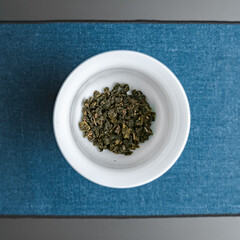 A bowl filled with freshly dried green tea leaves that emanate rich aromas and health benefits