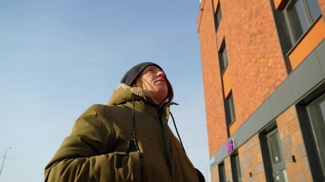 Capturing a moment of reflection under a clear blue sky in winter attire on a crisp day