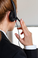 Rear view female office worker in headset.