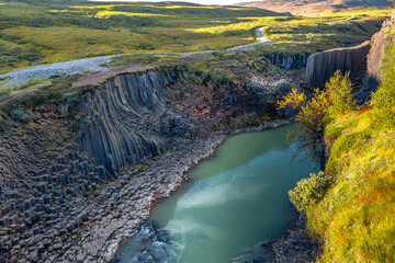 Basalt columns coloured orange by iron oxide, Studlagil Canyon, Egilsstadir, Austurland, Iceland