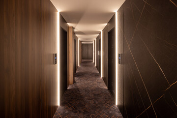 Interior of a long hotel corridor with wooden walls
