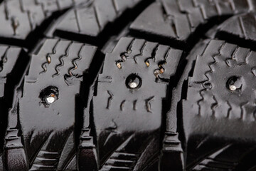 Broken studs on the surface of a car tire.